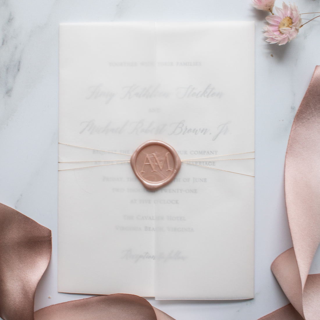 wax seal and rose gold thread wrapped around a letterpress wedding invitation