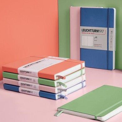 Stack of four colorful journals set against equally colorful background